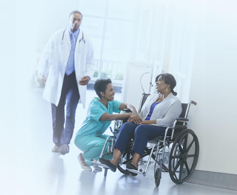 patient in wheel chair with providers nearby