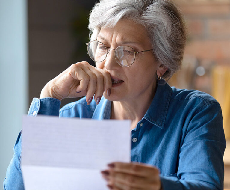 Photo of a senior woman reading a letter