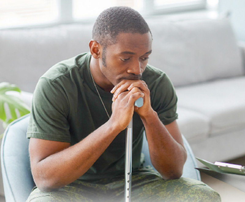 Man with a cane discussing his condition with a provider