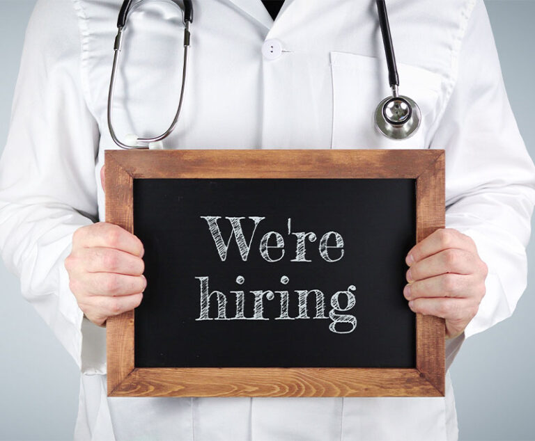 Doctor holding "we're hiring" sign