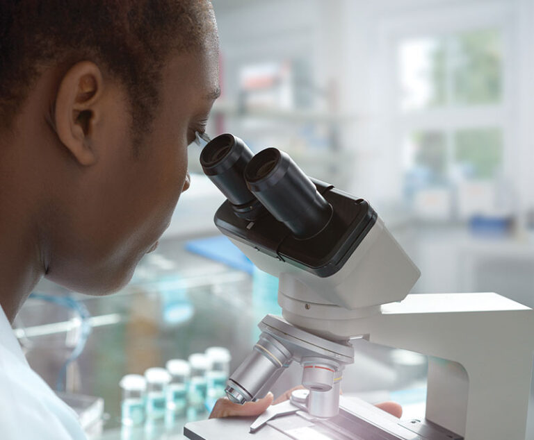 Researcher looking through microscope