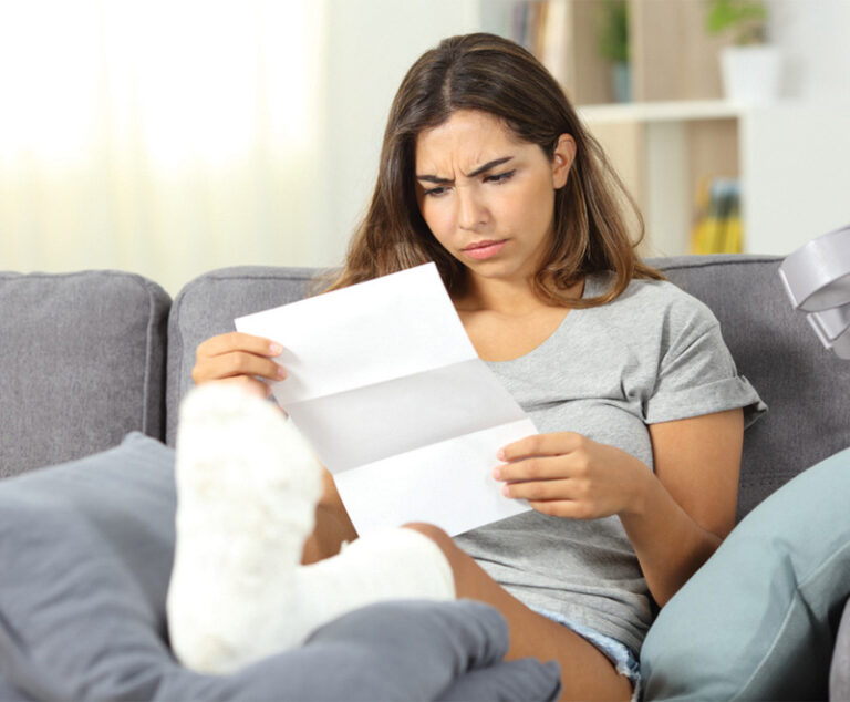 Photo of woman in leg cast reading a letter