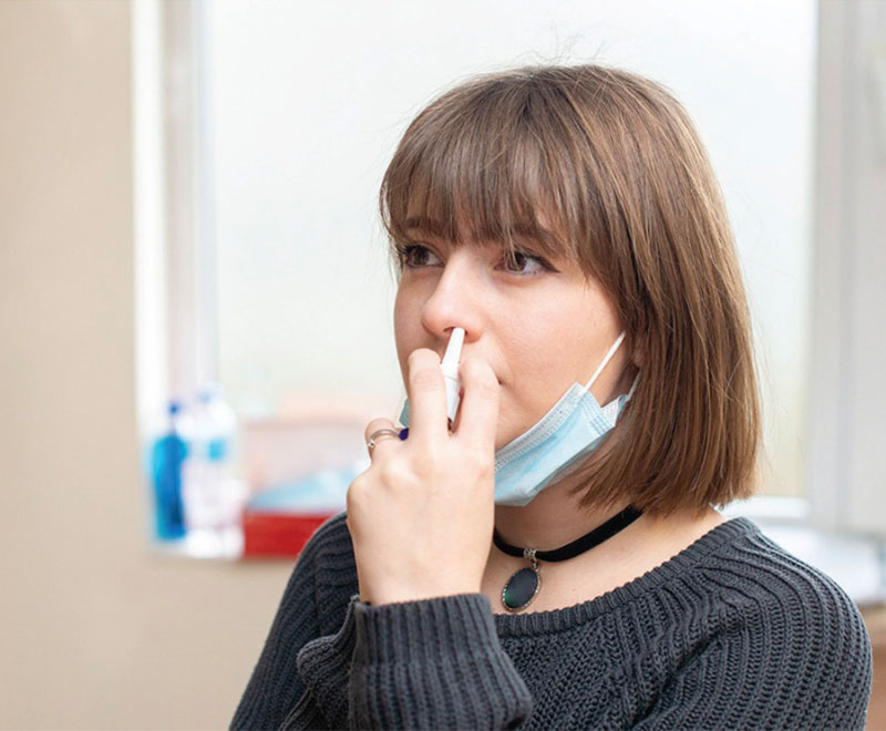 woman self-administering nasal flu vaccine