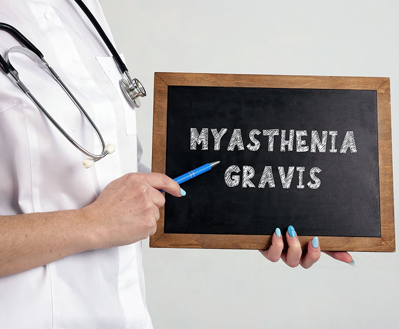 Image of a healthcare provider pointing to a chalkboard that says myasthenia gravis