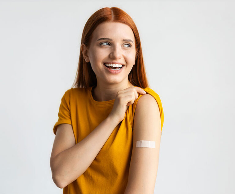 Photo of teen girl with bandaid on upper arm after receiving vaccine.